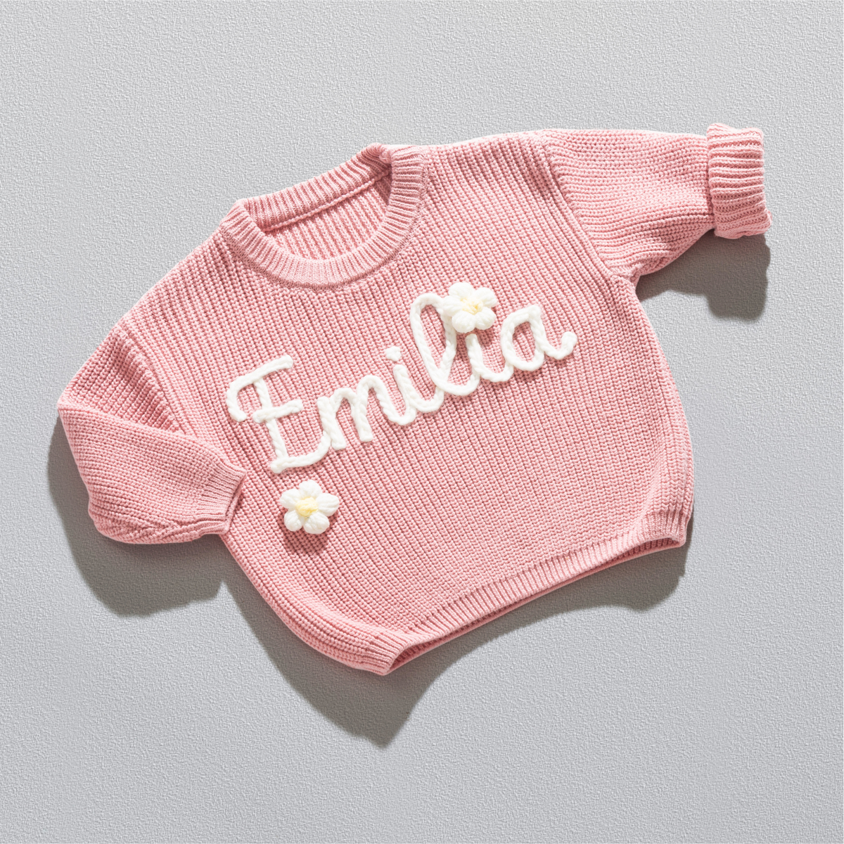 Personalisierter Strickpullover in Altrosa mit dem Namen Emilia, handgestickt in Off-White